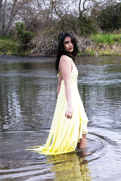 Unga indiska kvinnan stående i floden — Stockfoto