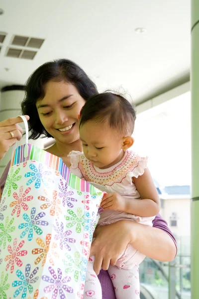Mother and baby with shopping bag — Stock Photo, Image