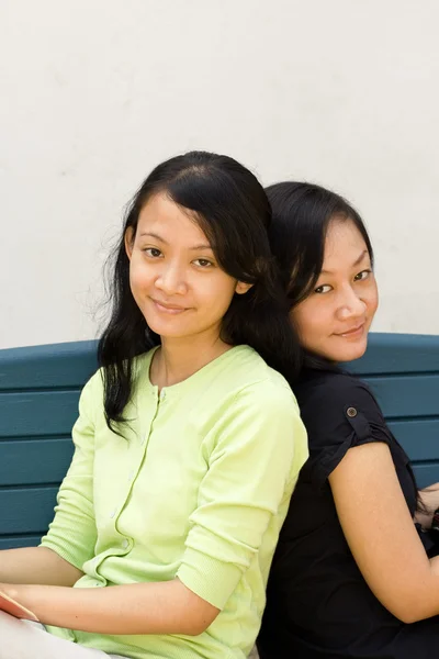 Zwei asiatische Mädchen zurück zu Rücken — Stockfoto
