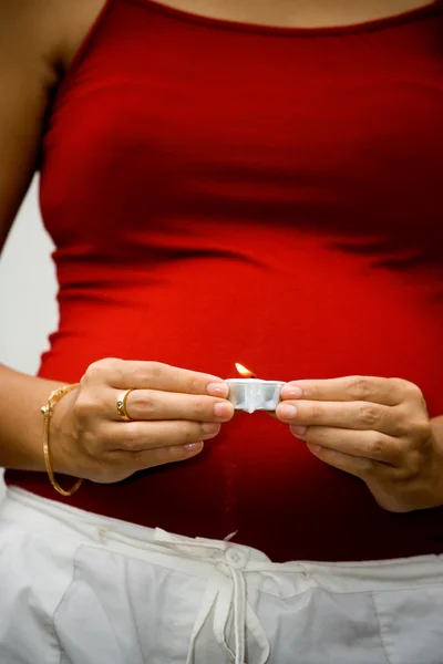 Mulher grávida com luz de vela nas mãos — Fotografia de Stock