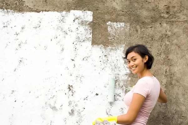 stock image Happy ethnic yougn woman painting house