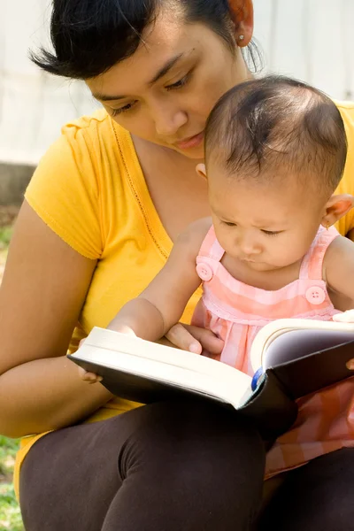 族裔母亲和婴儿读一本书 — 图库照片