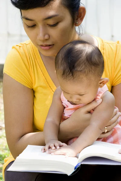Etniska mamma läsa en bok med barn — Stockfoto