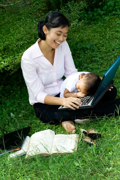 Çalışan ve çocuk ile oynamaya çalışan anne — Stok fotoğraf