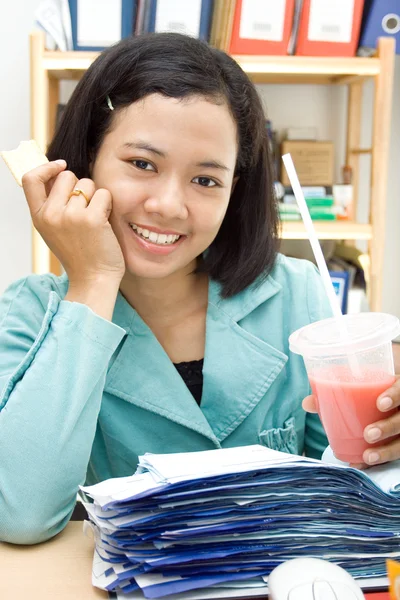 Etnische zakenvrouw gelukkig eten en drinken op het werk — Stockfoto