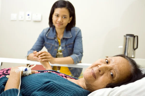 Etnické vnučka navštivte hospitalizované nemocné babičce — Stock fotografie