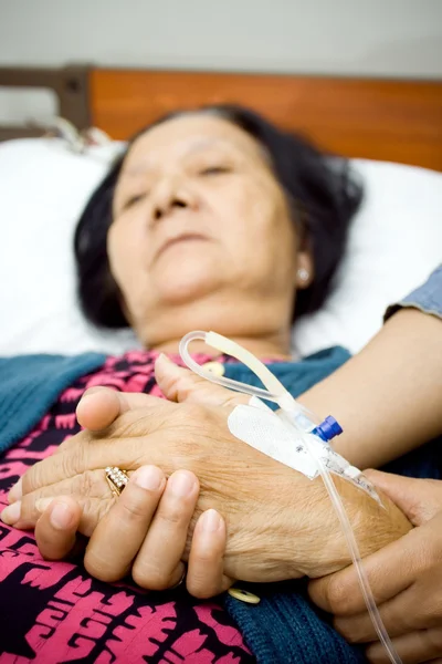 Hand van zieke oude vrouw wordt hold door dochter — Stockfoto