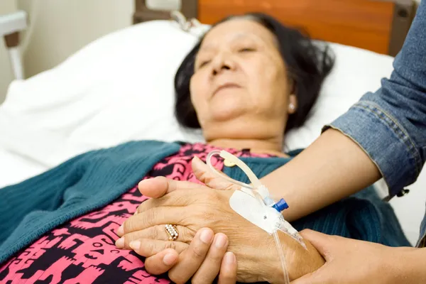 Handverzorging aan zieke bejaarden ouder — Stockfoto