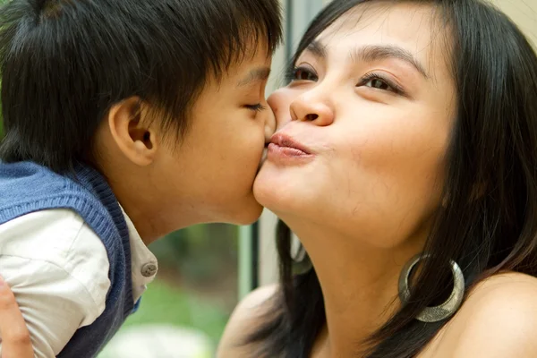 Asian child and mother kissing — Stock Photo, Image