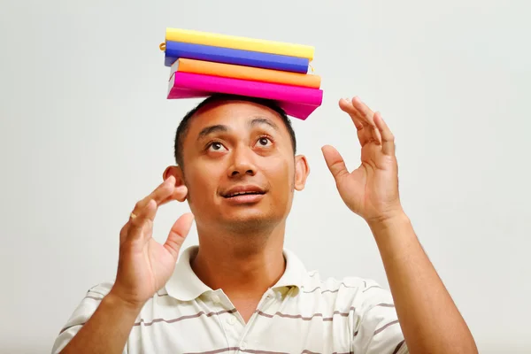 Etniczne młody człowiek równoważenia książki na głowie — Zdjęcie stockowe