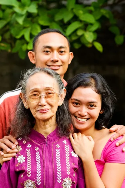 Happy asian young man and woman embrace old mother — Stock Photo, Image