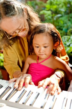 etnik yaşlı kadın çocuk oyun öğretmek piyano