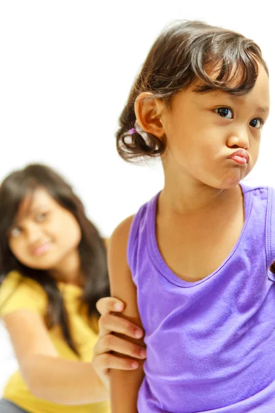Сестричка-подросток убеждает капризного ребенка — стоковое фото