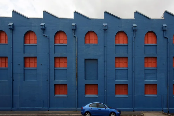 Edifício azul com carro azul — Fotografia de Stock