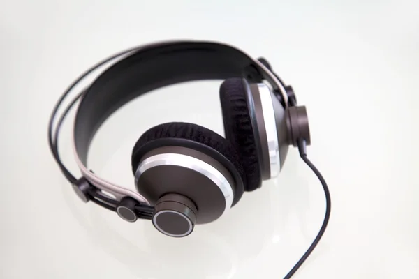 Stock image Headphones on a white and reflective background