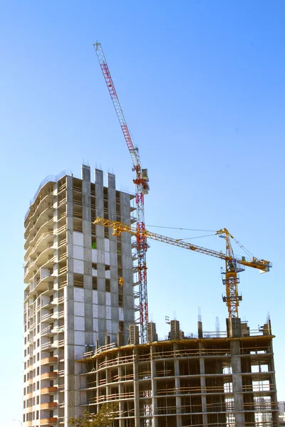 Byggingen av det moderne høydehuset mot den blå himmelen – stockfoto