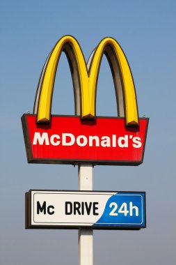 KYIV, UKRAINE - MARCH 18: McDonalds logo on blue sky background on March 18, 2012 in Kyiv, Ukraine. McDonald's Corporation is the world's largest chain of hamburger fast food restaurants. clipart