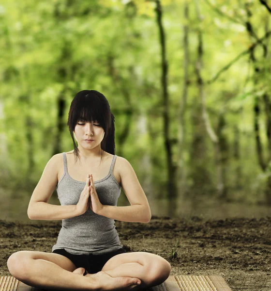 Asian Woman Meditating in Forest Stock Photo