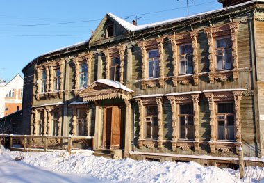 Facade of the old wooden building in winter clipart