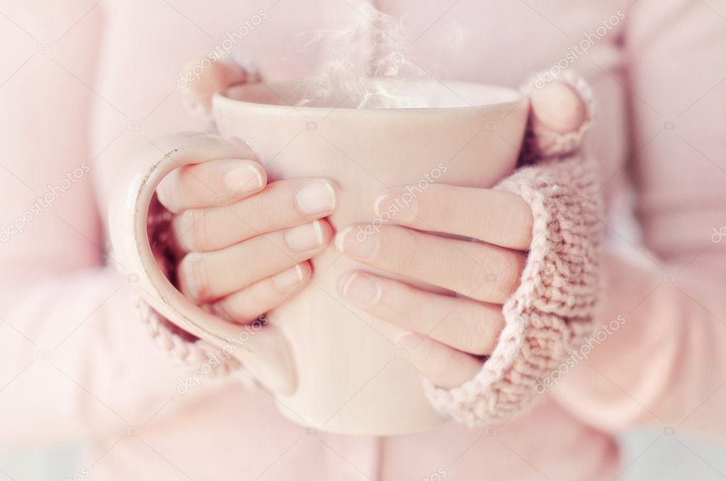 Hands of woman holding a cup