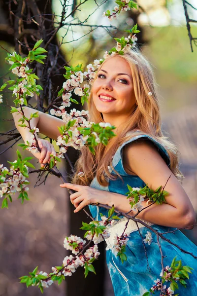 Portrait of beautiful woman in blooming tree in spring — Stock Photo, Image