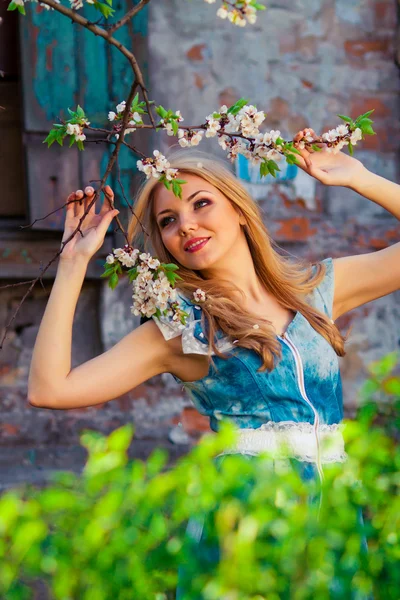 Portret van mooie vrouw in bloeiende boom in het voorjaar — Stockfoto