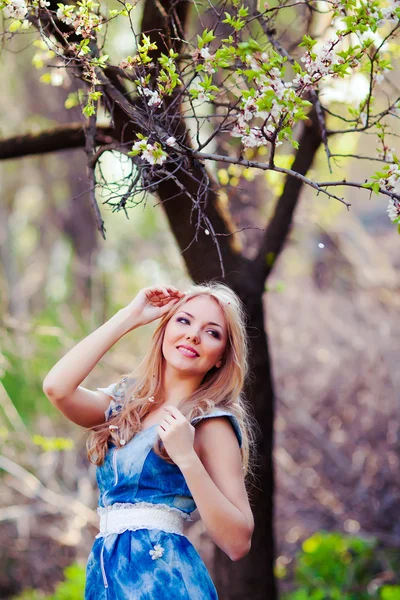 Porträt einer schönen Frau in einem blühenden Baum im Frühling — Stockfoto