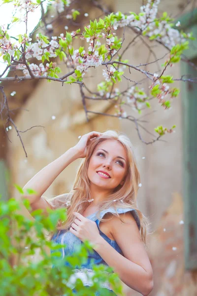 Porträtt av vacker kvinna i blommande träd på våren — Stockfoto