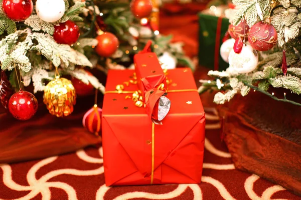 Stora gåva nära julgranar — Stockfoto