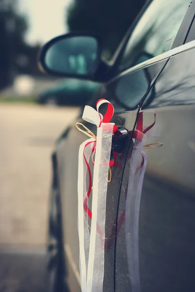 Hermosas cintas de boda en un coche — Foto de Stock
