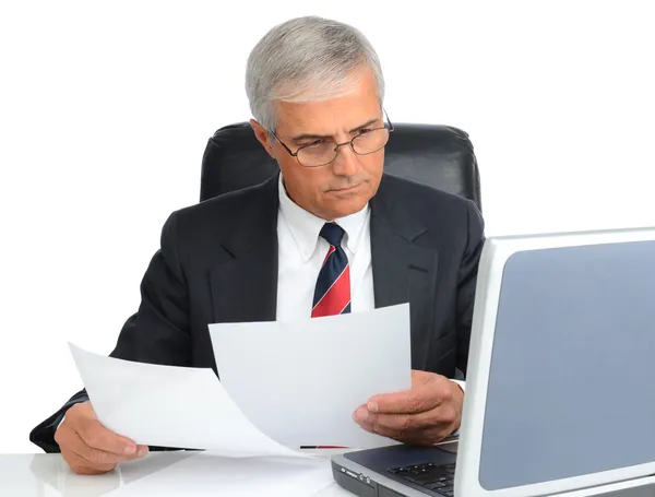 Бизнесмен за столом с компьютером и бумагами — стоковое фото
