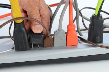 Man Inserting Plug into Power Strip clipart