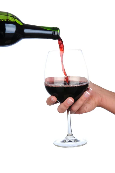 Вино наливается в стакан, который держит женская рука — стоковое фото