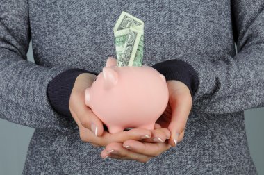 Woman holding Piggy Bank with Dollar clipart