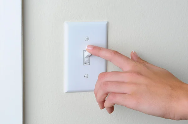 Mulher desligar interruptor de luz — Fotografia de Stock