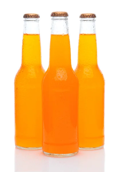 Três garrafas de refrigerante laranja no branco — Fotografia de Stock