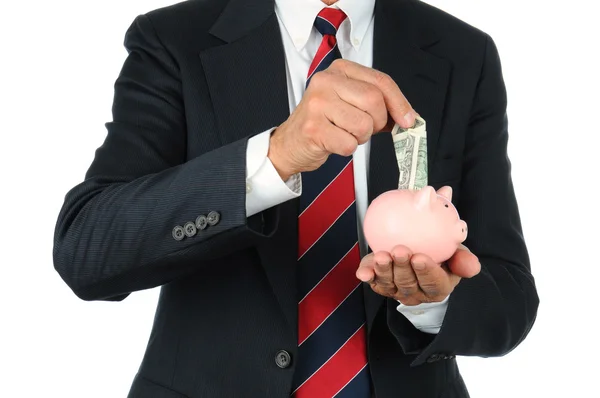 Geschäftsmann legt Geld in Sparschwein — Stockfoto