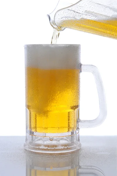 Pichet de bière versé dans une tasse — Photo
