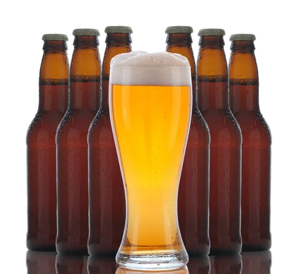 Vaso de cerveza con botellas detrás —  Fotos de Stock