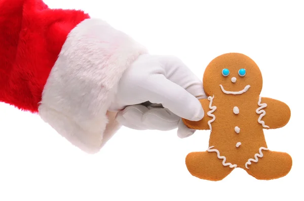 Weihnachtsmann hält Lebkuchenmann in der Hand — Stockfoto