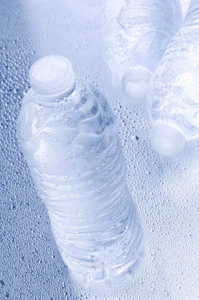 Botellas de agua en un borrón húmedo —  Fotos de Stock