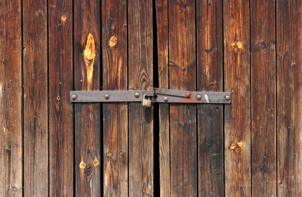 Porta de madeira velha trancada com cadeado enferrujado — Fotografia de Stock