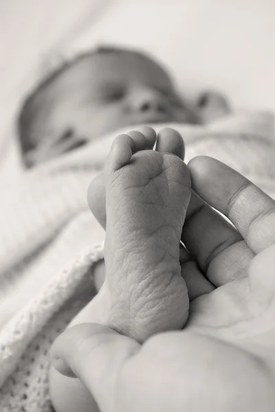 Tiny newborn foot in parent's hand — Stock Photo, Image