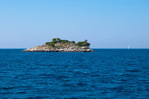 Small island and a yacht — Stock Photo, Image