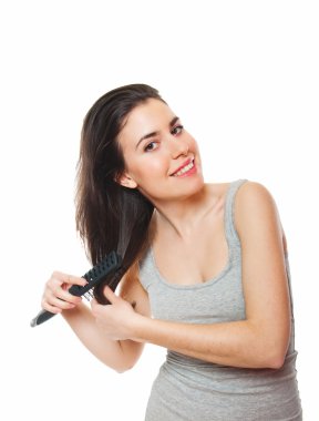 Beautiful young female combing her hair