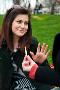 Young female rejects smoking offer clipart