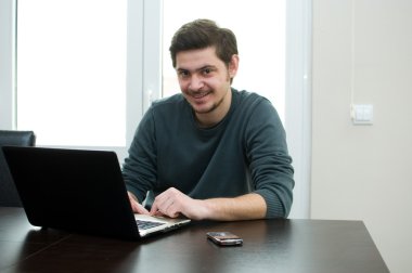 evde çalışan genç bir yetişkin portresi