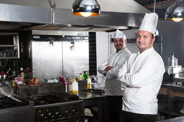 Retrato de dois chefs sorrindo e segurando utensílio de cozinha — Fotografia de Stock