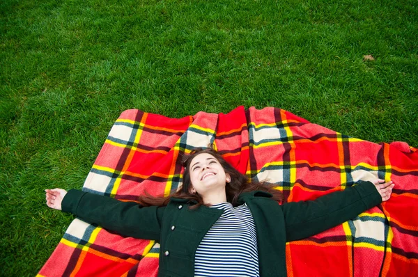 Porträt einer schönen jungen Frau, die im Gras liegt — Stockfoto