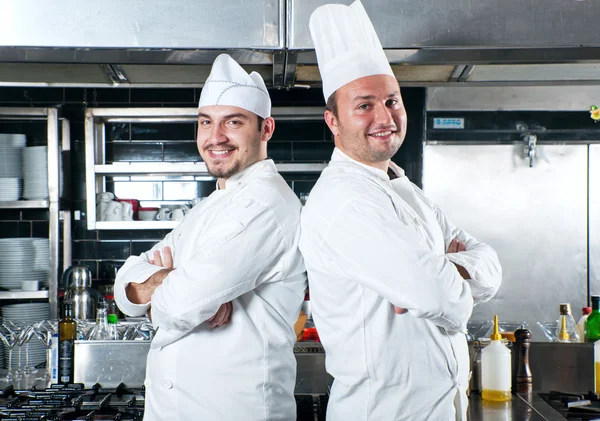 Portrét dvou kuchařů, usmíval se a drží kuchyňské nádobí — Stock fotografie